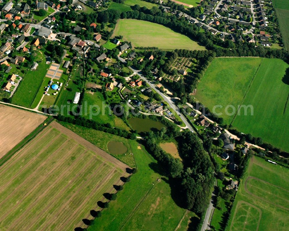 Aerial image Breitenfelde - Agricultural land and field boundaries surround the settlement area of the village in Breitenfelde in the state Schleswig-Holstein, Germany