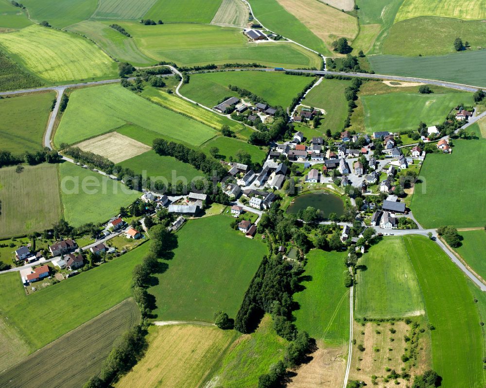 Bruck from above - Agricultural land and field boundaries surround the settlement area of the village in Bruck in the state Bavaria, Germany