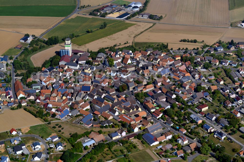 Bütthard from the bird's eye view: Agricultural land and field boundaries surround the settlement area of the village in Bütthard in the state Bavaria, Germany