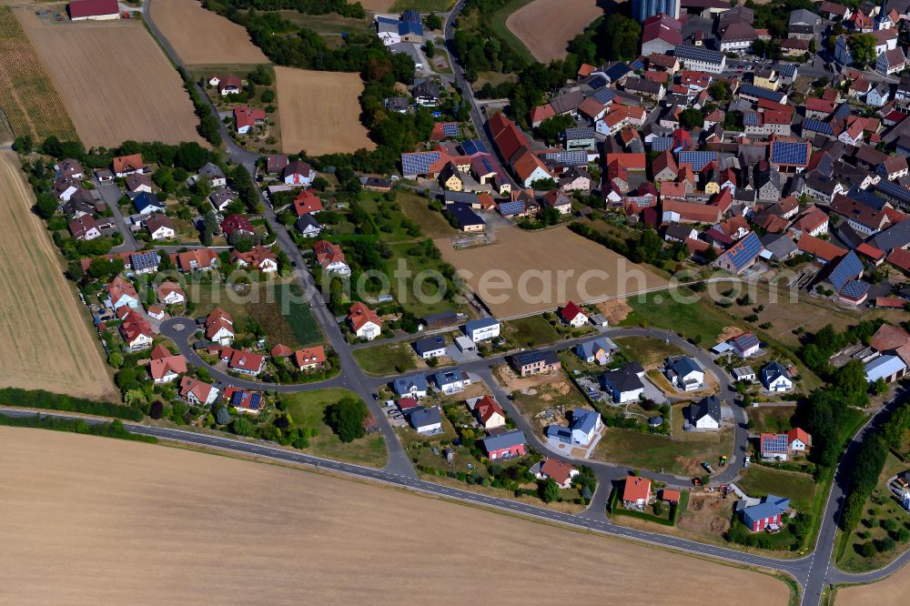 Aerial image Bütthard - Agricultural land and field boundaries surround the settlement area of the village in Bütthard in the state Bavaria, Germany