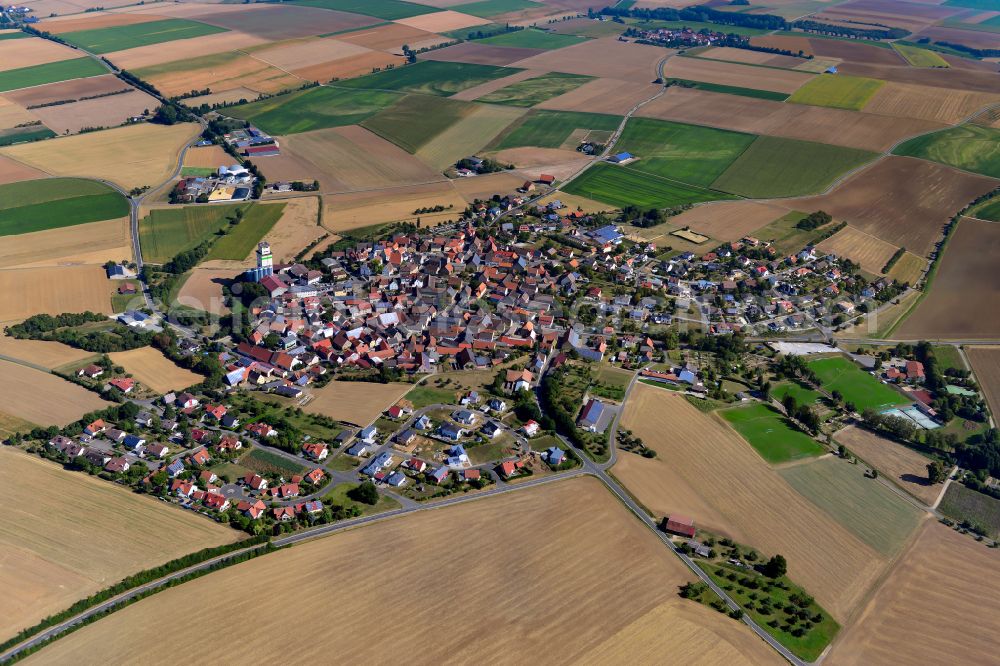 Aerial photograph Bütthard - Agricultural land and field boundaries surround the settlement area of the village in Bütthard in the state Bavaria, Germany