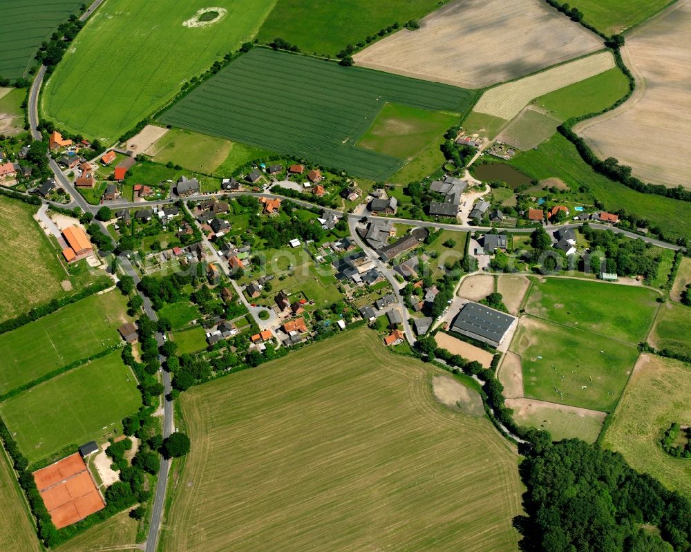 Bullenhorst from above - Agricultural land and field boundaries surround the settlement area of the village in Bullenhorst in the state Schleswig-Holstein, Germany