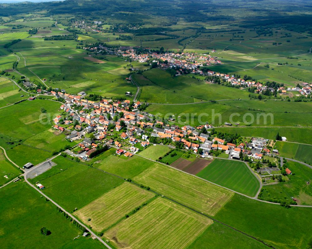 Crainfeld from above - Agricultural land and field boundaries surround the settlement area of the village in Crainfeld in the state Hesse, Germany