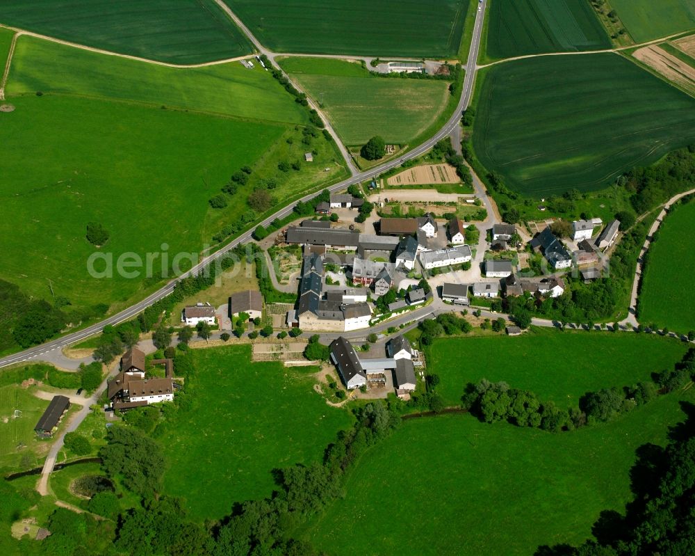 Aerial image Dauborn - Agricultural land and field boundaries surround the settlement area of the village in Dauborn in the state Hesse, Germany