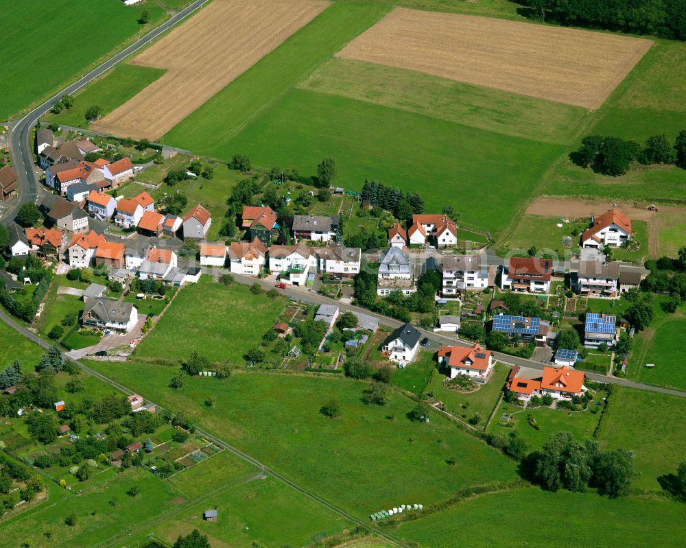 Aerial image Deckenbach - Agricultural land and field boundaries surround the settlement area of the village in Deckenbach in the state Hesse, Germany