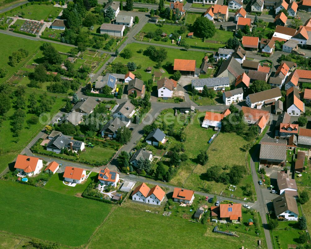 Aerial photograph Deckenbach - Agricultural land and field boundaries surround the settlement area of the village in Deckenbach in the state Hesse, Germany