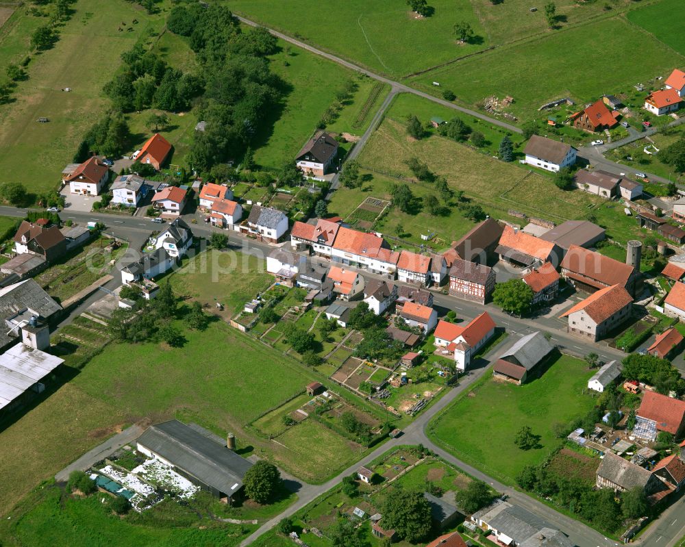 Deckenbach from above - Agricultural land and field boundaries surround the settlement area of the village in Deckenbach in the state Hesse, Germany