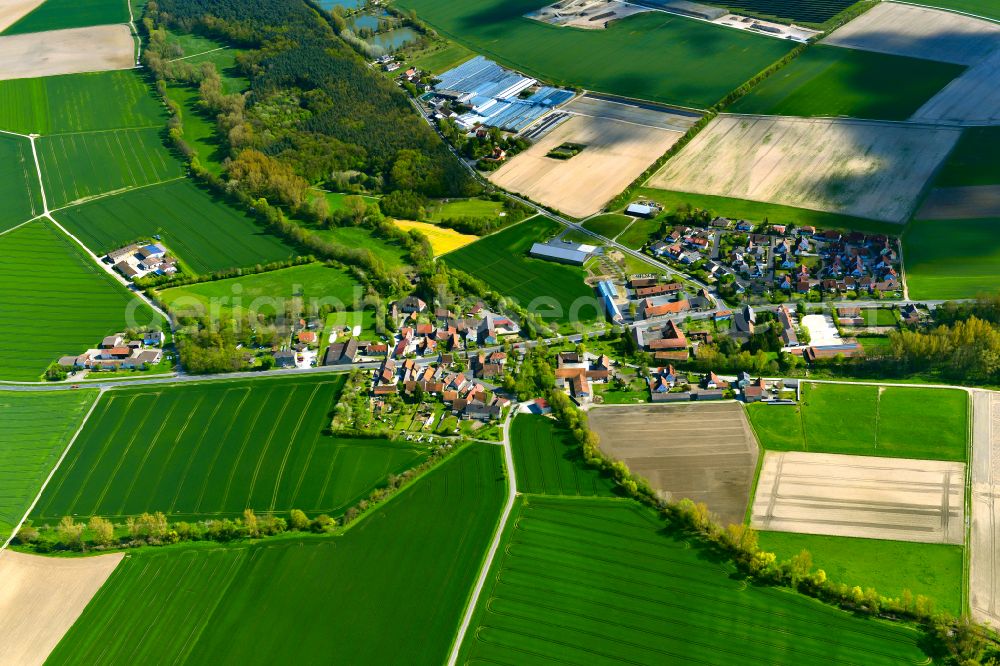 Düllstadt from the bird's eye view: Agricultural land and field boundaries surround the settlement area of the village in Düllstadt in the state Bavaria, Germany