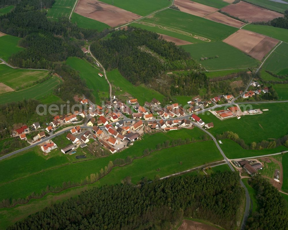 Ebersdorf from the bird's eye view: Agricultural land and field boundaries surround the settlement area of the village in Ebersdorf in the state Bavaria, Germany