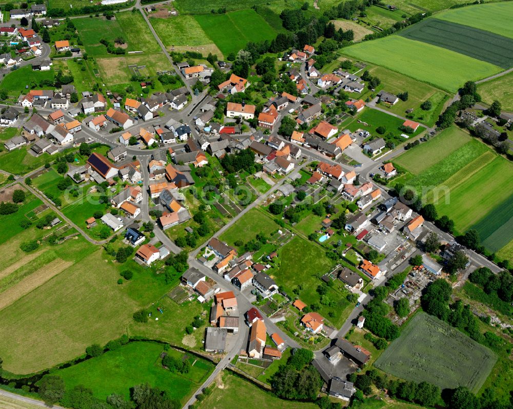 Ehringshausen from the bird's eye view: Agricultural land and field boundaries surround the settlement area of the village in Ehringshausen in the state Hesse, Germany