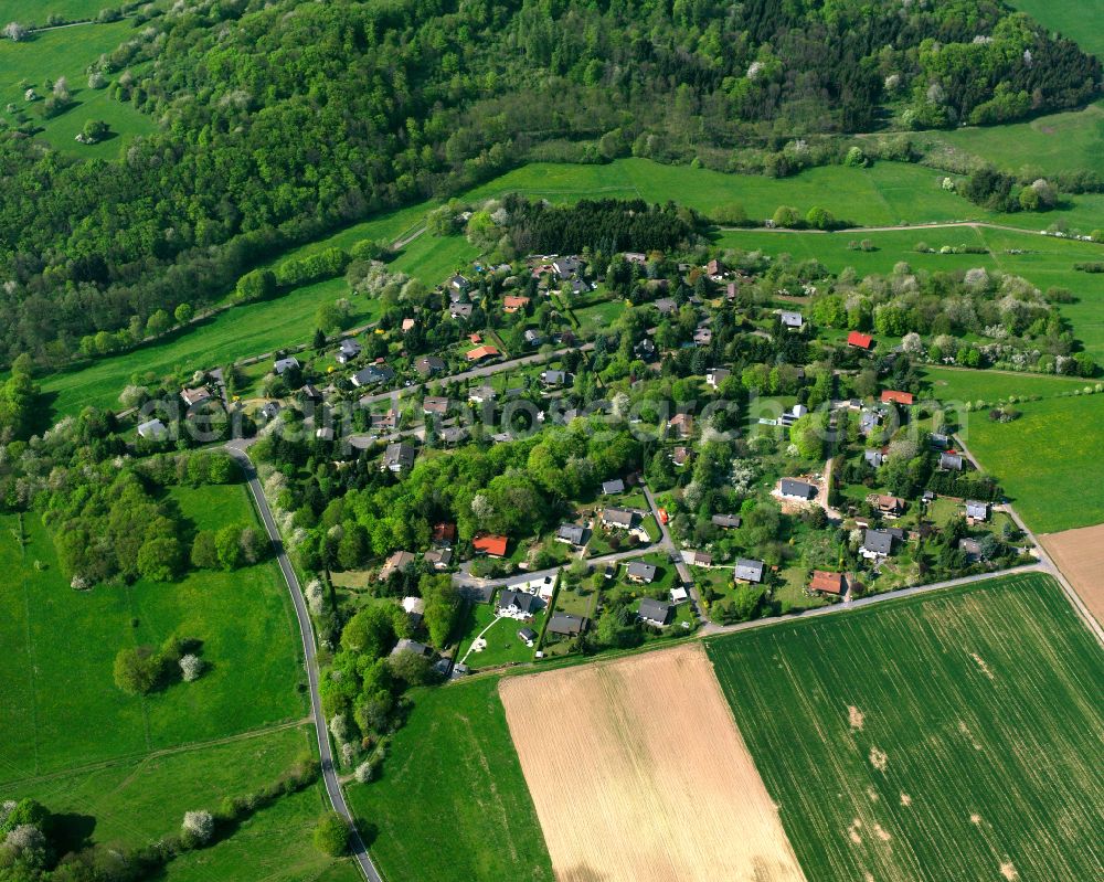 Eichelsachsen from the bird's eye view: Agricultural land and field boundaries surround the settlement area of the village in Eichelsachsen in the state Hesse, Germany