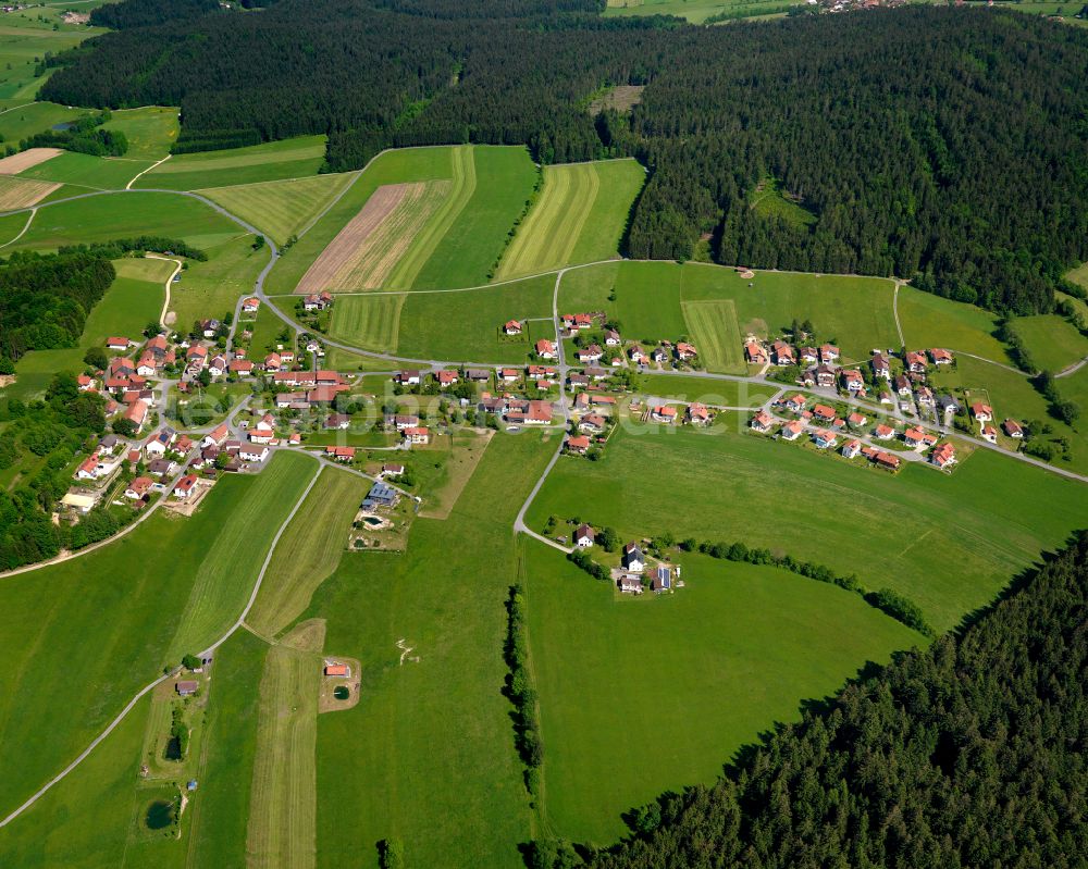 Elmberg from the bird's eye view: Agricultural land and field boundaries surround the settlement area of the village in Elmberg in the state Bavaria, Germany