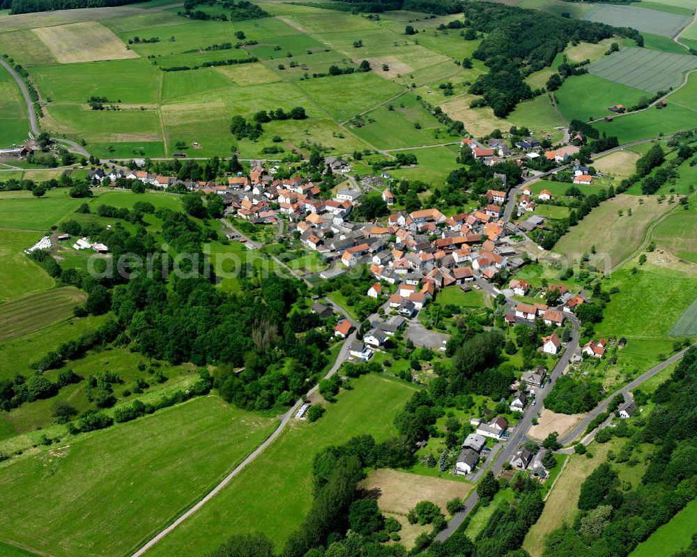 Elpenrod from the bird's eye view: Agricultural land and field boundaries surround the settlement area of the village in Elpenrod in the state Hesse, Germany