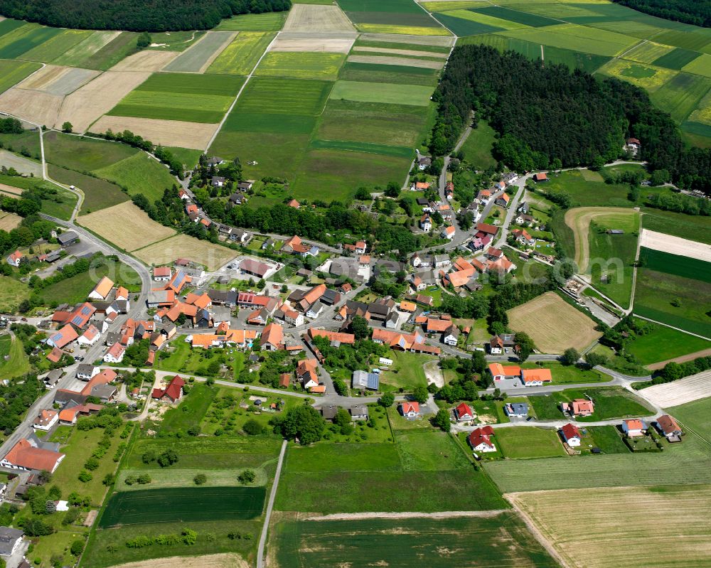 Aerial image Erbenhausen - Agricultural land and field boundaries surround the settlement area of the village in Erbenhausen in the state Hesse, Germany