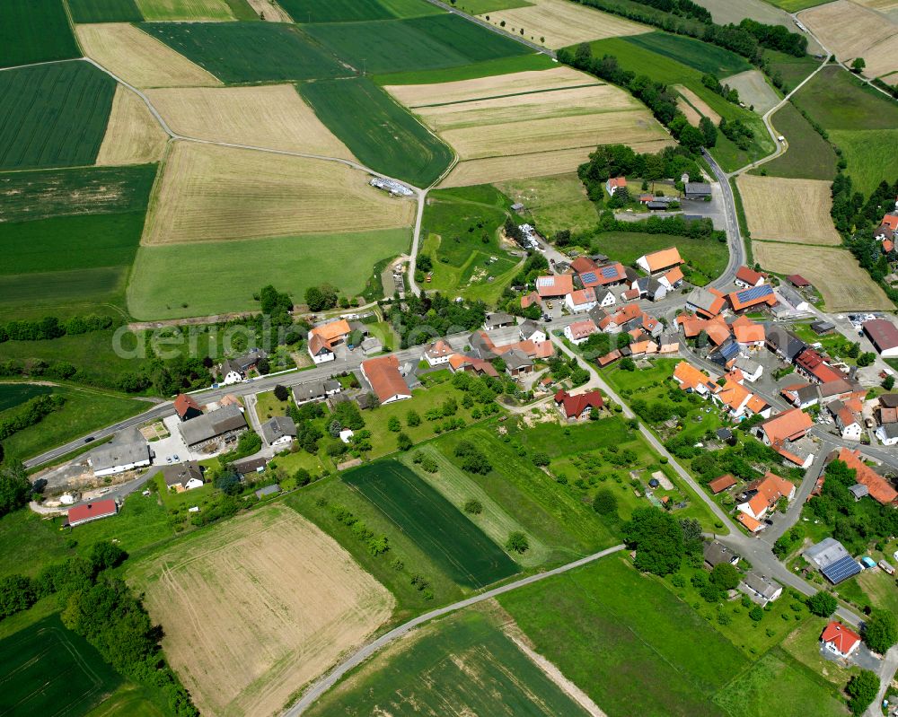 Erbenhausen from above - Agricultural land and field boundaries surround the settlement area of the village in Erbenhausen in the state Hesse, Germany