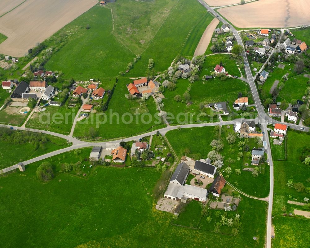 Erlau from the bird's eye view: Agricultural land and field boundaries surround the settlement area of the village in Erlau in the state Saxony, Germany