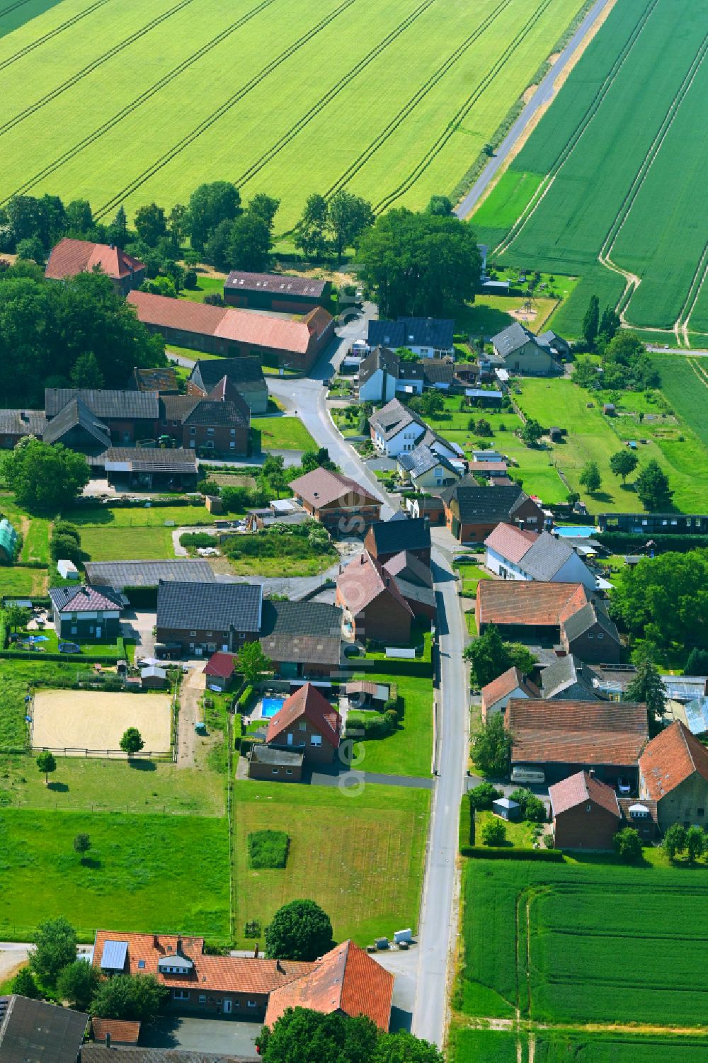 Ermsinghausen from the bird's eye view: Agricultural land and field boundaries surround the settlement area of the village in Ermsinghausen in the state North Rhine-Westphalia, Germany