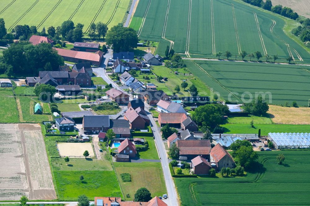 Ermsinghausen from the bird's eye view: Agricultural land and field boundaries surround the settlement area of the village in Ermsinghausen in the state North Rhine-Westphalia, Germany