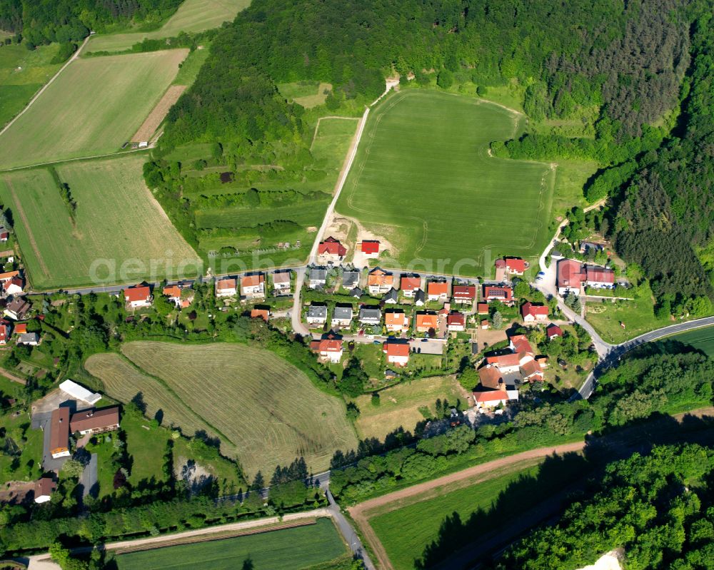 Ershausen from the bird's eye view: Agricultural land and field boundaries surround the settlement area of the village in Ershausen in the state Thuringia, Germany