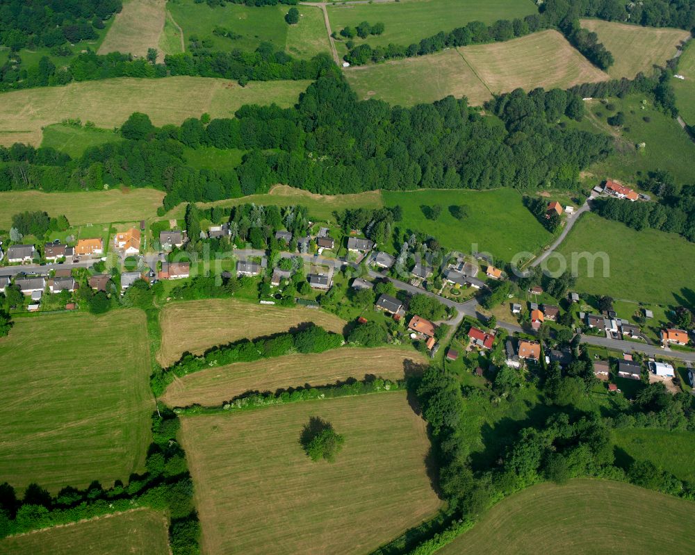 Eschenrod from above - Agricultural land and field boundaries surround the settlement area of the village in Eschenrod in the state Hesse, Germany