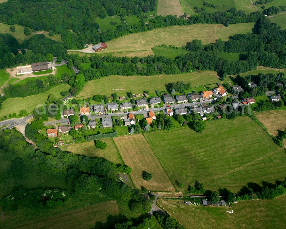 Eschenrod from the bird's eye view: Agricultural land and field boundaries surround the settlement area of the village in Eschenrod in the state Hesse, Germany