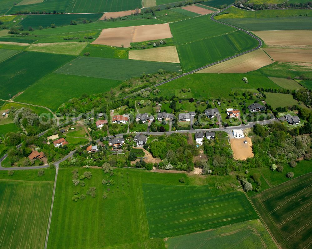 Ettingshausen from above - Agricultural land and field boundaries surround the settlement area of the village in Ettingshausen in the state Hesse, Germany