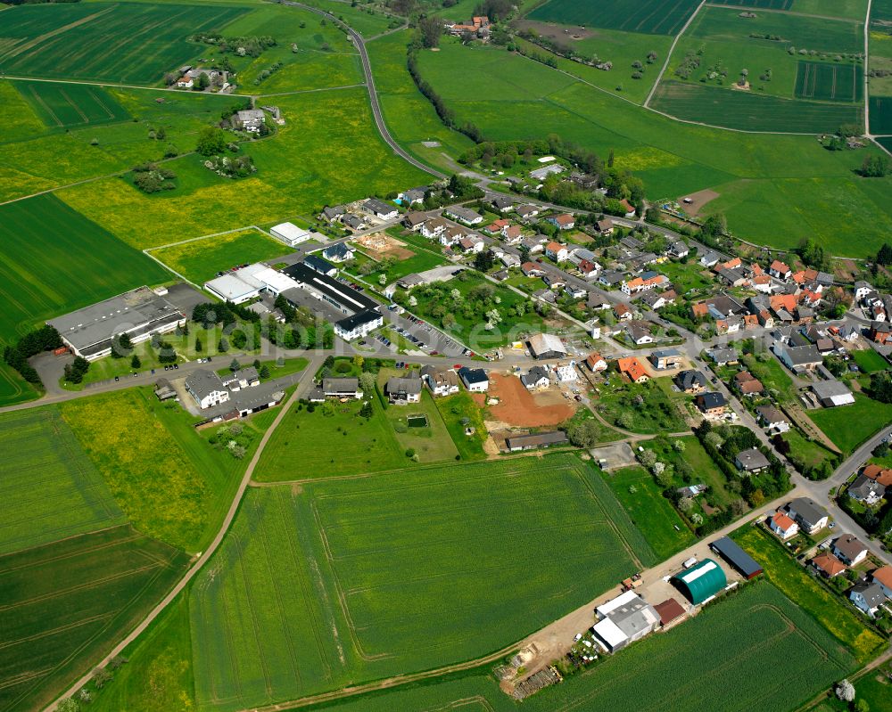 Aerial image Ettingshausen - Agricultural land and field boundaries surround the settlement area of the village in Ettingshausen in the state Hesse, Germany