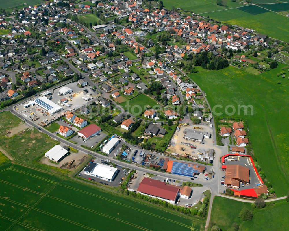 Ettingshausen from above - Agricultural land and field boundaries surround the settlement area of the village in Ettingshausen in the state Hesse, Germany