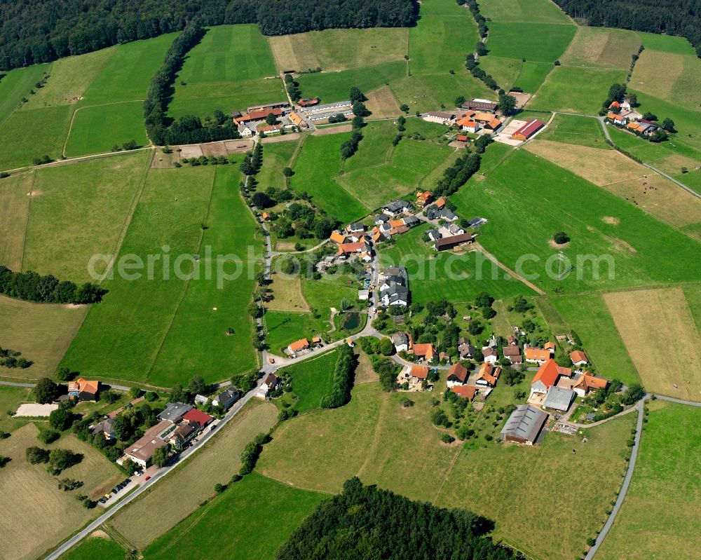 Aerial photograph Etzean - Agricultural land and field boundaries surround the settlement area of the village in Etzean in the state Hesse, Germany