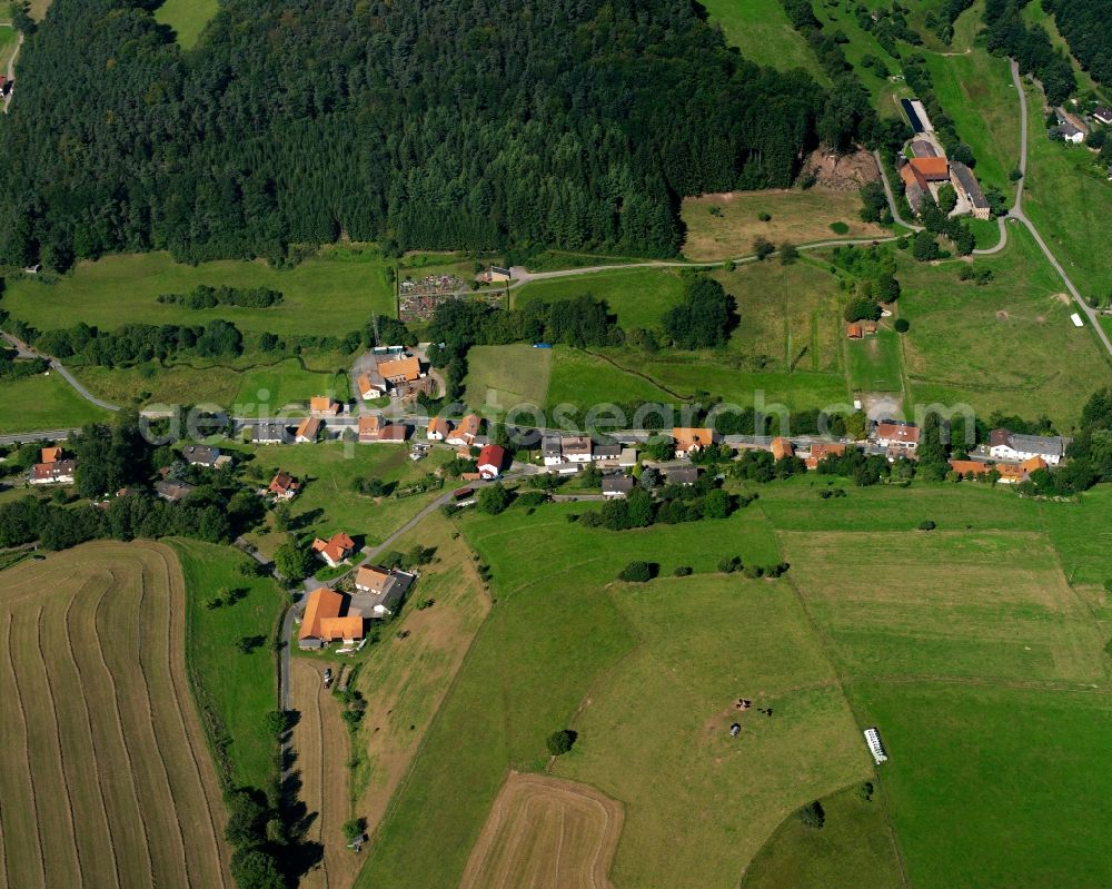 Falken-Gesäß from the bird's eye view: Agricultural land and field boundaries surround the settlement area of the village in Falken-Gesäß in the state Hesse, Germany