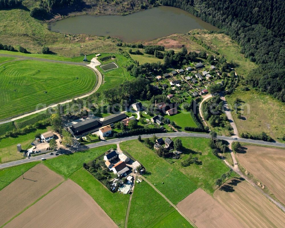 Falkenau from above - Agricultural land and field boundaries surround the settlement area of the village in Falkenau in the state Saxony, Germany