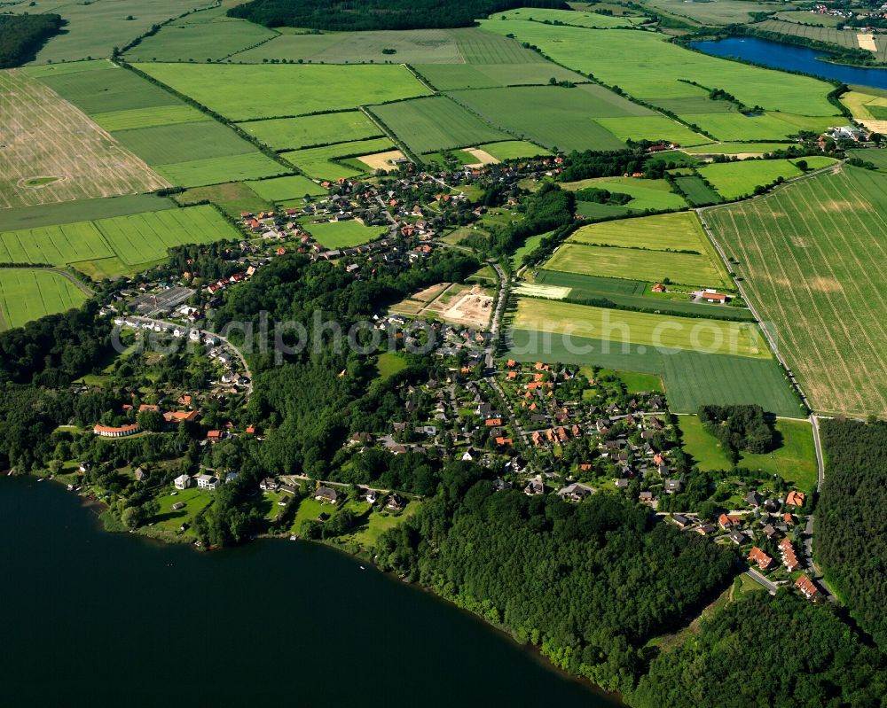 Farchauer Mühle from the bird's eye view: Agricultural land and field boundaries surround the settlement area of the village in Farchauer Mühle in the state Schleswig-Holstein, Germany