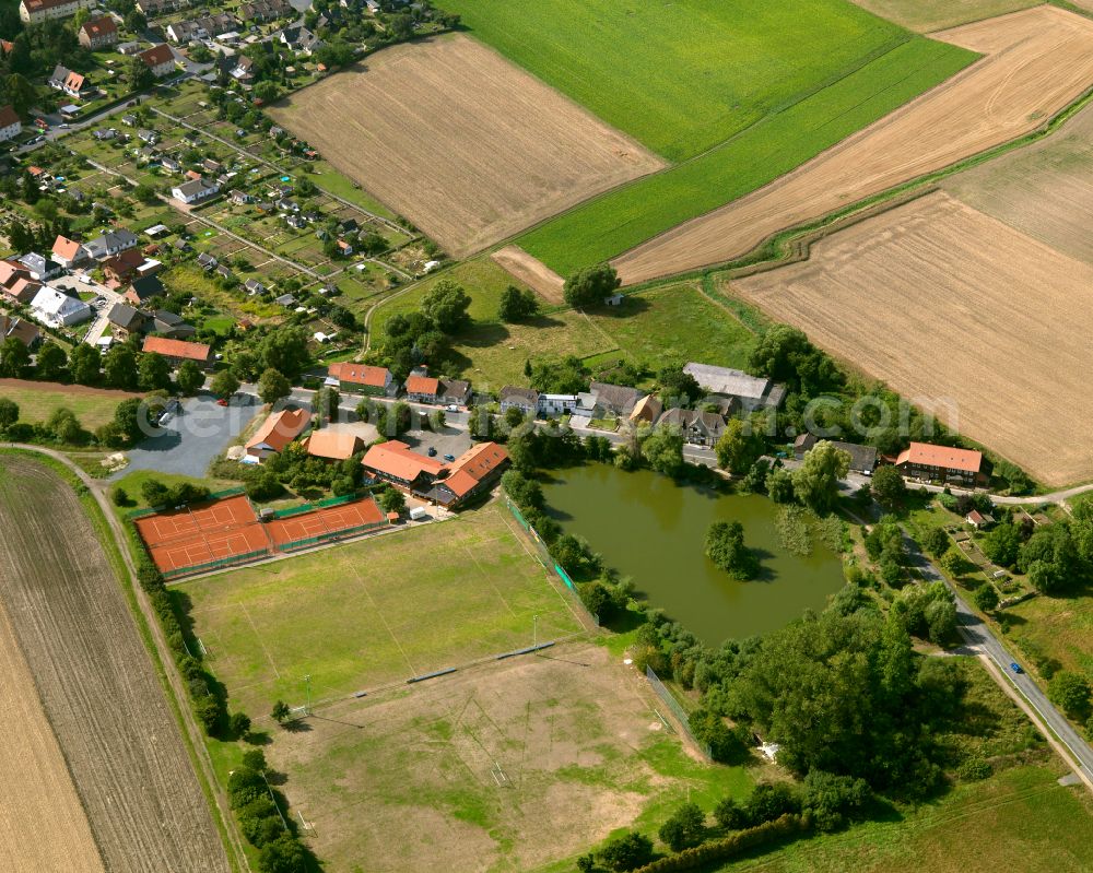 Flachstöckheim from the bird's eye view: Agricultural land and field boundaries surround the settlement area of the village in Flachstöckheim in the state Lower Saxony, Germany