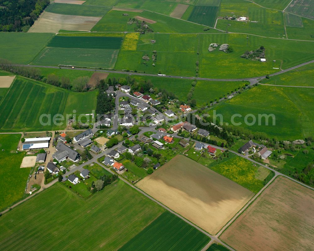 Flugplatzsiedlung Ettinghausen from the bird's eye view: Agricultural land and field boundaries surround the settlement area of the village in Flugplatzsiedlung Ettinghausen in the state Hesse, Germany