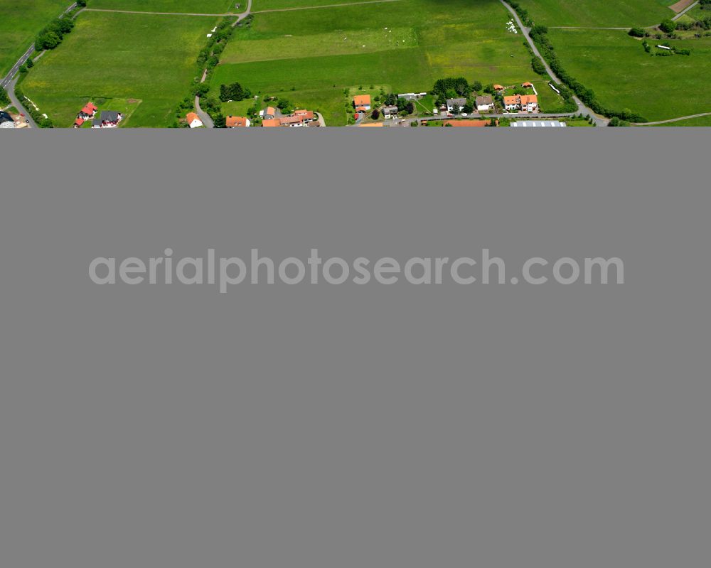 Freiensteinau from above - Agricultural land and field boundaries surround the settlement area of the village in Freiensteinau in the state Hesse, Germany