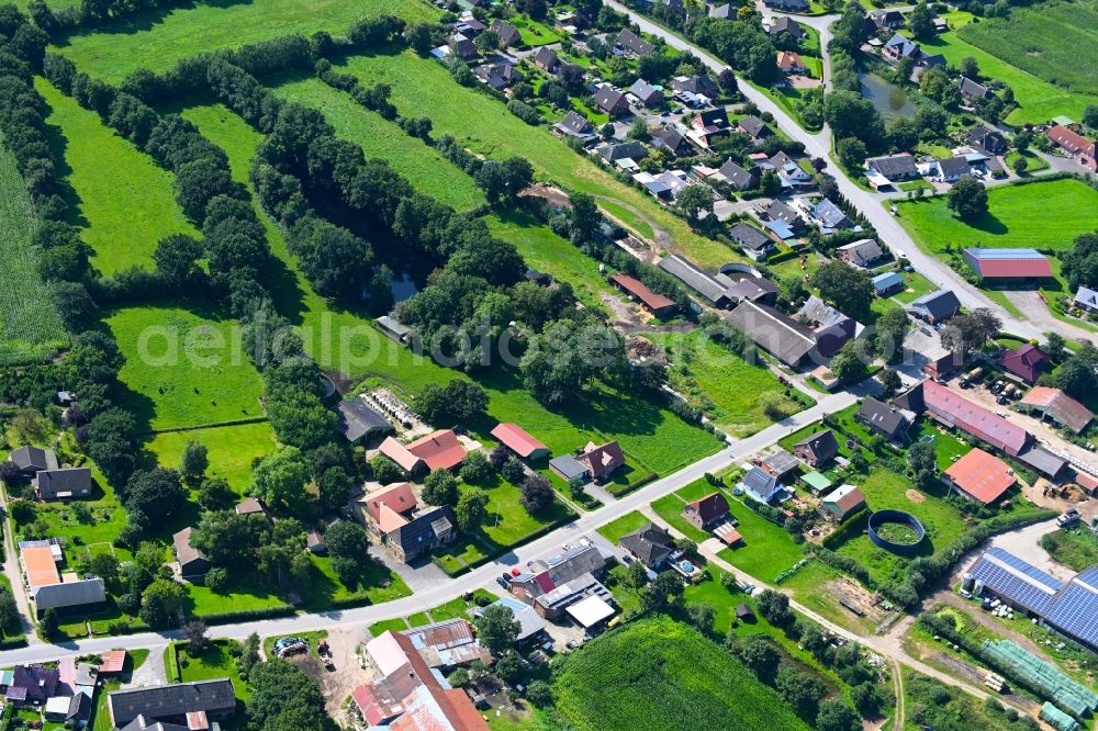 Friedrichsholm from the bird's eye view: Agricultural land and field boundaries surround the settlement area of the village in Friedrichsholm in the state Schleswig-Holstein, Germany