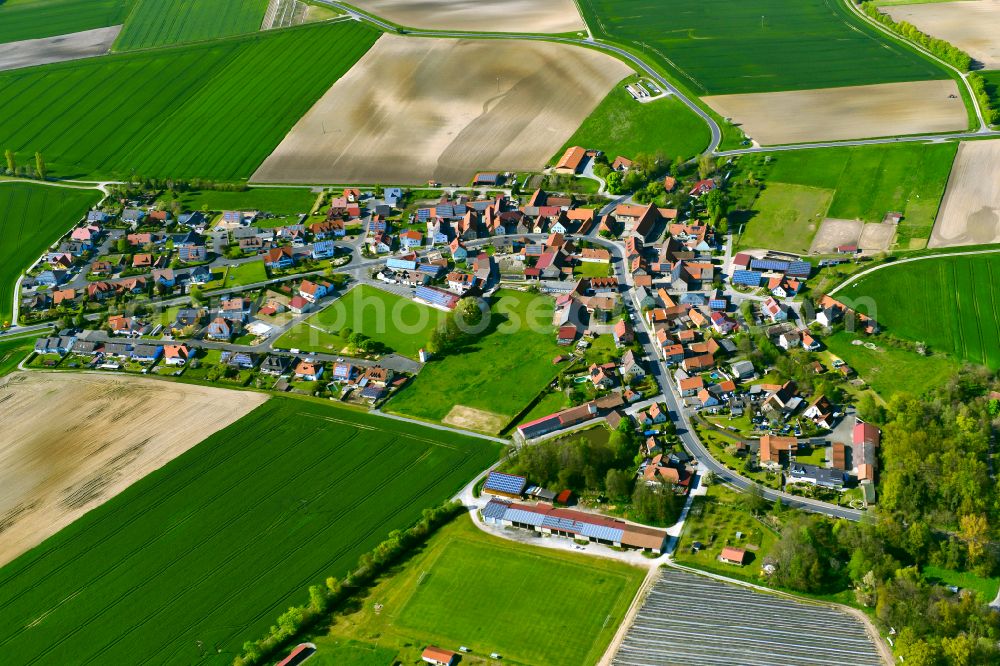 Geesdorf from above - Agricultural land and field boundaries surround the settlement area of the village in Geesdorf in the state Bavaria, Germany