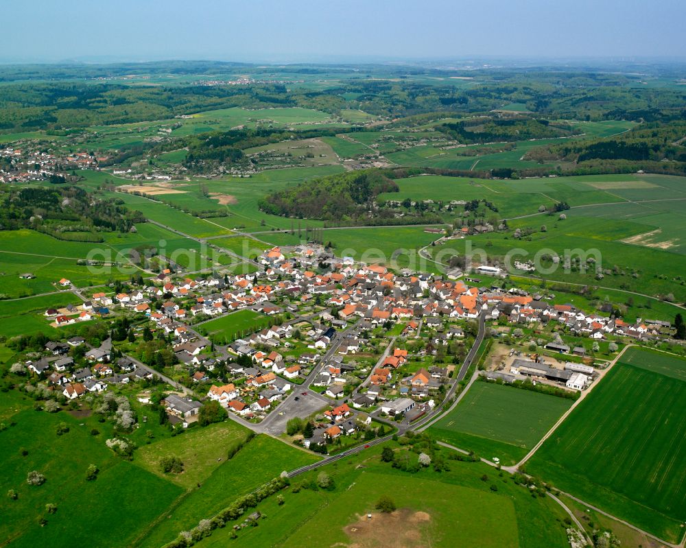 Geilshausen from above - Agricultural land and field boundaries surround the settlement area of the village in Geilshausen in the state Hesse, Germany