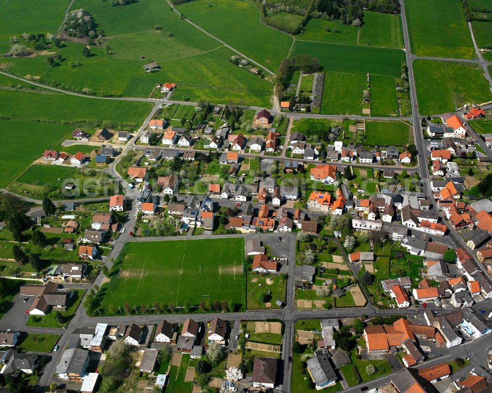 Geilshausen from the bird's eye view: Agricultural land and field boundaries surround the settlement area of the village in Geilshausen in the state Hesse, Germany