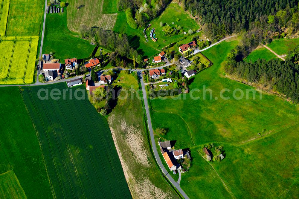 Geiselwind from above - Agricultural land and field boundaries surround the settlement area of the village in Geiselwind in the state Bavaria, Germany