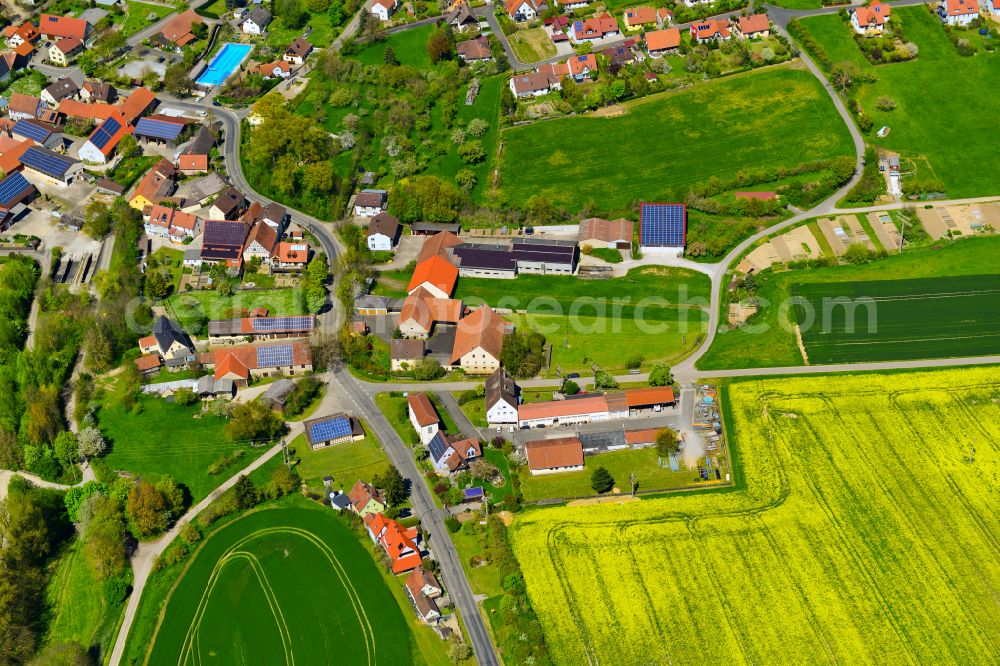 Gnötzheim from the bird's eye view: Agricultural land and field boundaries surround the settlement area of the village in Gnötzheim in the state Bavaria, Germany