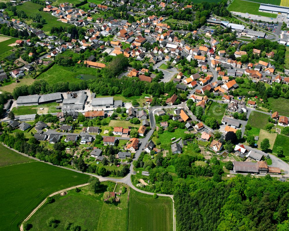 Aerial image Grebenau - Agricultural land and field boundaries surround the settlement area of the village in Grebenau in the state Hesse, Germany