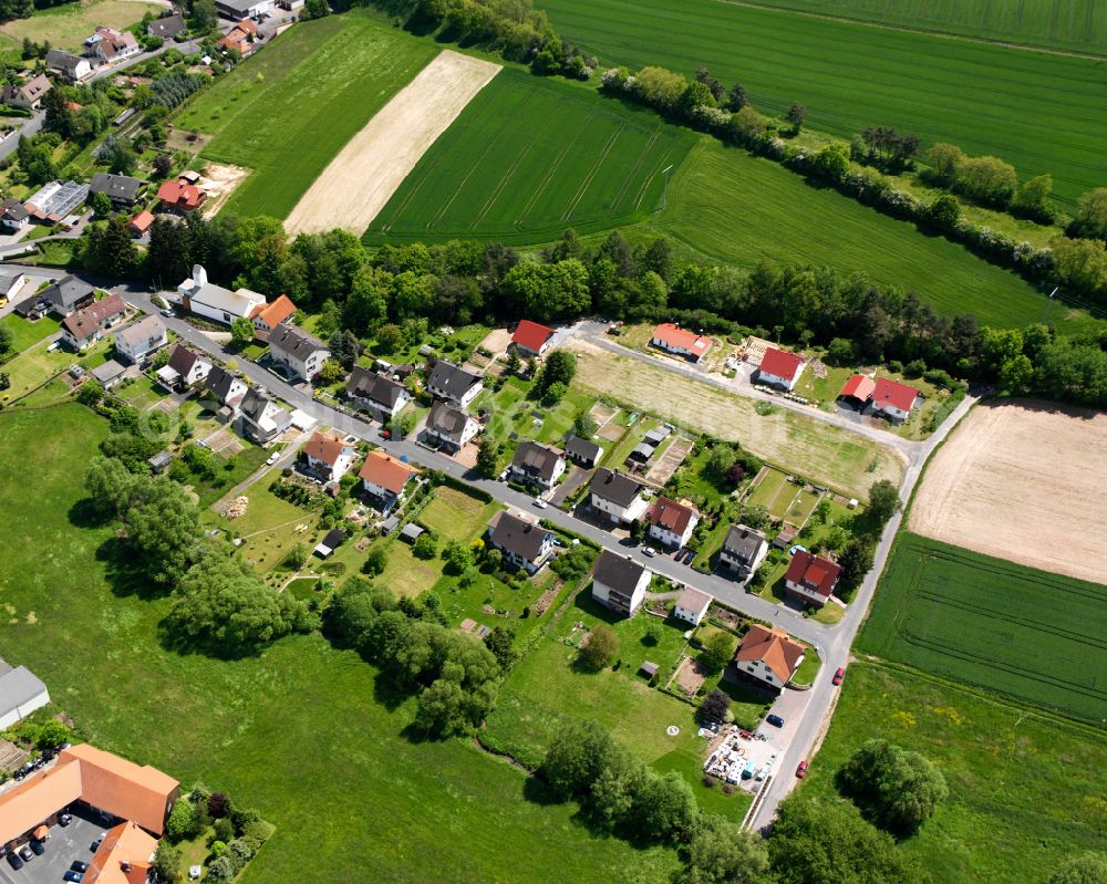 Aerial photograph Grebenau - Agricultural land and field boundaries surround the settlement area of the village in Grebenau in the state Hesse, Germany