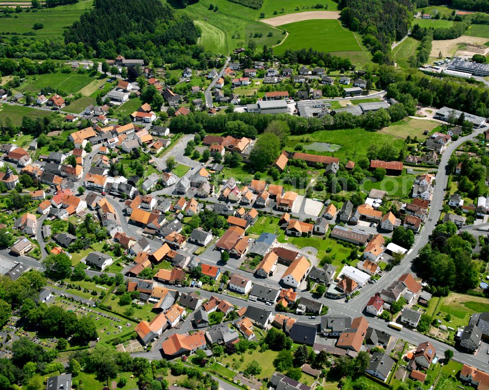 Grebenau from above - Agricultural land and field boundaries surround the settlement area of the village in Grebenau in the state Hesse, Germany