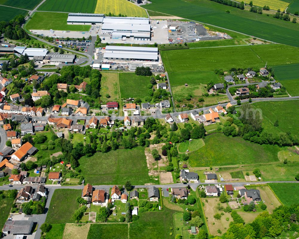 Grebenau from the bird's eye view: Agricultural land and field boundaries surround the settlement area of the village in Grebenau in the state Hesse, Germany