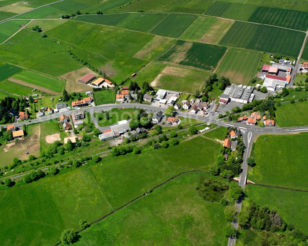 Grebenhain from the bird's eye view: Agricultural land and field boundaries surround the settlement area of the village in Grebenhain in the state Hesse, Germany