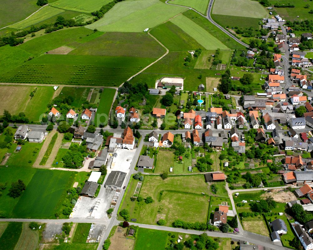 Aerial image Groß Eichen - Agricultural land and field boundaries surround the settlement area of the village in Groß Eichen in the state Hesse, Germany