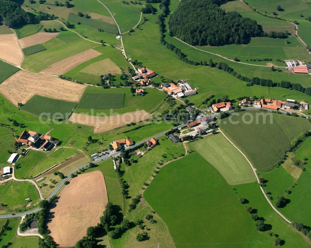 Gumpen from above - Agricultural land and field boundaries surround the settlement area of the village in Gumpen in the state Hesse, Germany