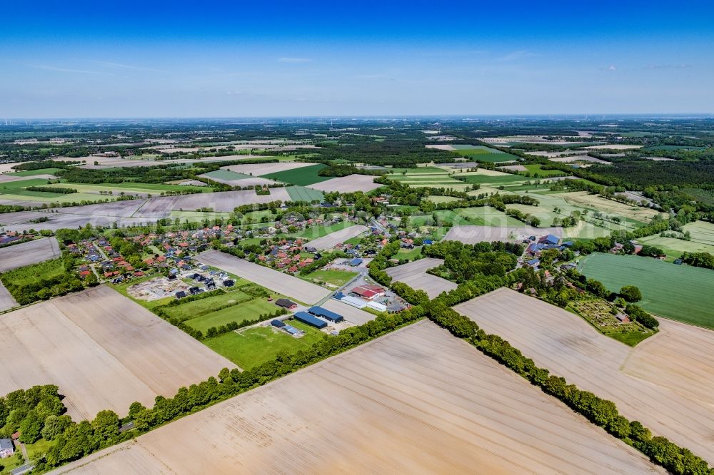 Hagenah from above - Agricultural land and field boundaries surround the settlement area of the village in Hagenah in the state Lower Saxony, Germany