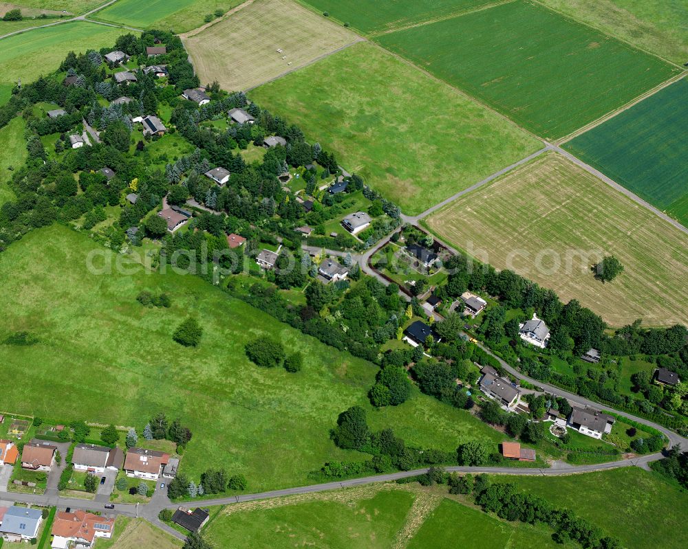 Hainbach from above - Agricultural land and field boundaries surround the settlement area of the village in Hainbach in the state Hesse, Germany